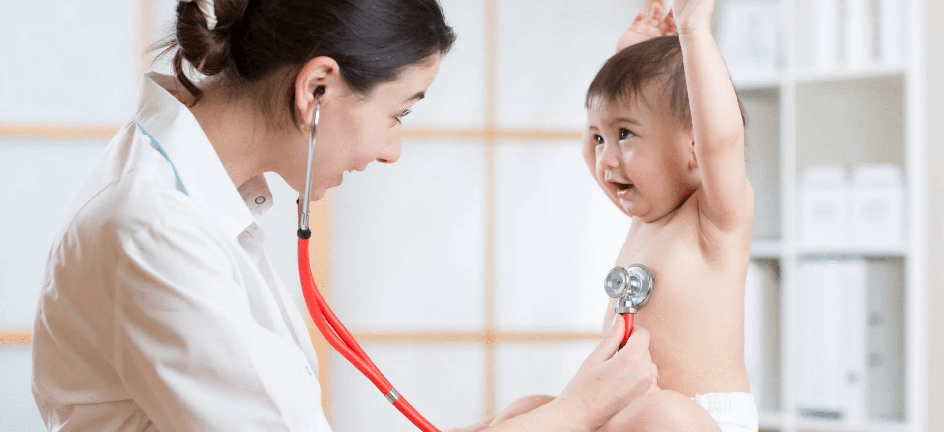 Pediatrician and neonatologist examining a child in a hospital setting